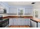 Well-lit kitchen with stainless steel appliances, butcher block counters, and stylish blue cabinets at 8340 Coventry Ct, North Charleston, SC 29420