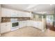 Well-equipped kitchen with white appliances, granite countertops, tile flooring, and an open view to the living room at 8739 Grassy Oak Trl, North Charleston, SC 29420