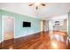 Inviting living room featuring hardwood floors, a ceiling fan, a wall-mounted TV, and neutral paint colors at 8739 Grassy Oak Trl, North Charleston, SC 29420