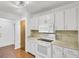 A bright kitchen featuring white cabinets, laminate countertops, a microwave, and laminate flooring at 103 Greencastle Dr, Goose Creek, SC 29445