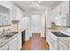 Well-lit kitchen with white cabinets, modern appliances, laminate countertops, and wood-look laminate flooring at 103 Greencastle Dr, Goose Creek, SC 29445