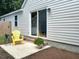 Outdoor patio area with yellow Adirondack chair, side table, potted flowers, and a sliding glass door at 108 Alston Cir, Goose Creek, SC 29445