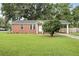 Charming brick home with manicured lawn, mature tree, and a convenient carport at 1105 Crull Dr, Charleston, SC 29407