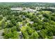 Aerial view of a neighborhood with lush trees, homes, and nearby commercial area at 1203 Forestwood Dr, Charleston, SC 29407