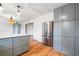 Spacious kitchen featuring gray cabinetry, a stainless steel refrigerator, hardwood floors, and elegant pendant lighting at 1203 Forestwood Dr, Charleston, SC 29407