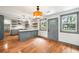 Open-concept kitchen and dining area with hardwood floors and modern light fixtures at 1203 Forestwood Dr, Charleston, SC 29407