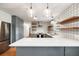 A modern kitchen with stainless steel appliances, large island, white countertop and floating shelves at 1203 Forestwood Dr, Charleston, SC 29407