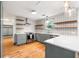 Modern kitchen with gray cabinets, stainless steel appliances, open shelving, and stylish backsplash, seamlessly blending style and functionality at 1203 Forestwood Dr, Charleston, SC 29407