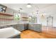 Open kitchen design features gray cabinets, floating wood shelves, and a center island with white countertop at 1203 Forestwood Dr, Charleston, SC 29407