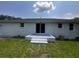 Backyard featuring a white brick home, small patio, and grassy area at 1229 Winston St, Charleston, SC 29407