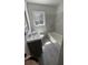 Bathroom features a tub and shower combo, grey tiles, and a window for natural light at 1229 Winston St, Charleston, SC 29407