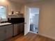 Kitchen with updated cabinets, floating shelves, and view into utility area at 1229 Winston St, Charleston, SC 29407