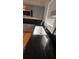 Modern kitchen sink featuring black marble countertops and black tile backsplash at 1229 Winston St, Charleston, SC 29407
