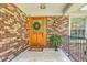 Charming front entrance with a wooden door, decorative wreath, and brick facade at 133 Axtell Dr, Summerville, SC 29485