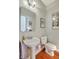 Elegant half-bathroom features a pedestal sink, toilet, and decorative mirror and artwork at 1343 Headquarters Plantation Dr, Johns Island, SC 29455