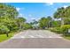 Welcoming community entrance with an iron gate, American flag, and lush tropical landscaping at 1343 Headquarters Plantation Dr, Johns Island, SC 29455