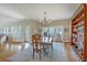 Open-concept dining area with wood floors, chandelier, and access to outside, adjacent to a shelving unit at 1343 Headquarters Plantation Dr, Johns Island, SC 29455