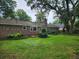 A backyard with green grass, mature trees, and a brick home in a serene setting at 1389 Parkshore Dr, Charleston, SC 29407