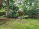 This serene backyard offers a tranquil setting with mature landscaping and a cozy bench at 1389 Parkshore Dr, Charleston, SC 29407