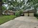 Inviting single-story brick home with attached two-car garage and lush landscaping along driveway at 1389 Parkshore Dr, Charleston, SC 29407