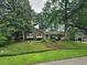 Lovely brick home surrounded by mature trees and lush greenery, showcasing a well-maintained landscape at 1389 Parkshore Dr, Charleston, SC 29407