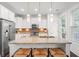 Sleek kitchen featuring white cabinetry, granite countertops, stainless steel appliances, and a stylish island with seating at 1582 Prince Edward St, Mount Pleasant, SC 29466