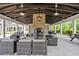 Inviting outdoor lounge area with ample seating, brick fireplace, and exposed timber beams at 1582 Prince Edward St, Mount Pleasant, SC 29466