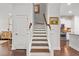 Elegant staircase featuring wood treads, white risers, and a view to the kitchen at 1582 Prince Edward St, Mount Pleasant, SC 29466