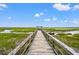Wooden walkway leads to open views, amidst a vast marsh and bright sky at 1582 Prince Edward St, Mount Pleasant, SC 29466