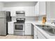 Well-lit kitchen with white cabinets, stainless steel appliances, and tiled floors at 1600 Long Grove Dr # 423, Mount Pleasant, SC 29464