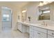 Bright bathroom with double sink vanity, neutral tile flooring, and framed mirror at 1619 Cultivation Ln, Mount Pleasant, SC 29466