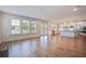 Spacious open-concept living room with large windows, hardwood floors, and a view into the modern kitchen at 1619 Cultivation Ln, Mount Pleasant, SC 29466
