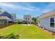 Expansive backyard featuring a fire pit, screened-in porch, lush lawn, and fenced perimeter at 1666 Sparkleberry Ln, Johns Island, SC 29455