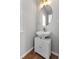 Powder room featuring white vanity with round mirror and wood look flooring at 1666 Sparkleberry Ln, Johns Island, SC 29455