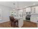Modern kitchen with stainless steel appliances, island seating, and white cabinetry at 1666 Sparkleberry Ln, Johns Island, SC 29455
