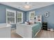 Cozy blue bedroom with a white bed, complementing furniture, ceiling fan and natural light from dual windows at 1728 Wellstead St, Mount Pleasant, SC 29466