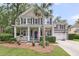 Charming two-story home with a welcoming front porch, beautiful landscaping, and an American flag at 1728 Wellstead St, Mount Pleasant, SC 29466