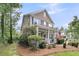 Inviting two-story home with a covered front porch, American flag, and lush, green landscaping at 1728 Wellstead St, Mount Pleasant, SC 29466