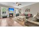 Cozy living room with fireplace, TV, ceiling fan, and large windows providing natural light at 1728 Wellstead St, Mount Pleasant, SC 29466