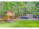 Backyard featuring a wooden playhouse, covered boat, and storage area, set amongst lush trees at 196 Dogwood Ridge Rd, Summerville, SC 29485