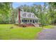 View of home with metal roof and welcoming front porch, situated in a lush, green lawn at 196 Dogwood Ridge Rd, Summerville, SC 29485