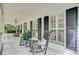 Inviting front porch featuring rocking chairs, shuttered windows, and outdoor lighting at 196 Dogwood Ridge Rd, Summerville, SC 29485