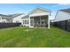 Backyard view of the screened in patio, featuring green grass, and a black fence at 198 Steepbrook Dr, Summerville, SC 29486