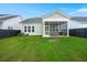 Backyard view of the screened in patio, green grass, and privacy fence at 198 Steepbrook Dr, Summerville, SC 29486
