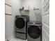 Well-equipped laundry room with modern washer and dryer units and shelving at 198 Steepbrook Dr, Summerville, SC 29486