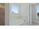 Large soaking tub with tile surround, a window and view to the main bedroom at 206 Terrace View Dr, Summerville, SC 29486