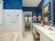 Bathroom featuring blue walls, a double sink vanity, bathtub and an open doorway to a bedroom at 206 White Gables Dr, Summerville, SC 29483