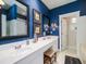 Bathroom featuring blue walls, a double sink vanity, tiled floors, and a large framed mirror at 206 White Gables Dr, Summerville, SC 29483