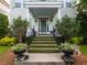 Inviting front porch with manicured bushes, flower pots, a decorative wreath, and elegant black railings at 206 White Gables Dr, Summerville, SC 29483