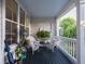 Cozy front porch seating area with white wicker chairs and charming plants at 206 White Gables Dr, Summerville, SC 29483